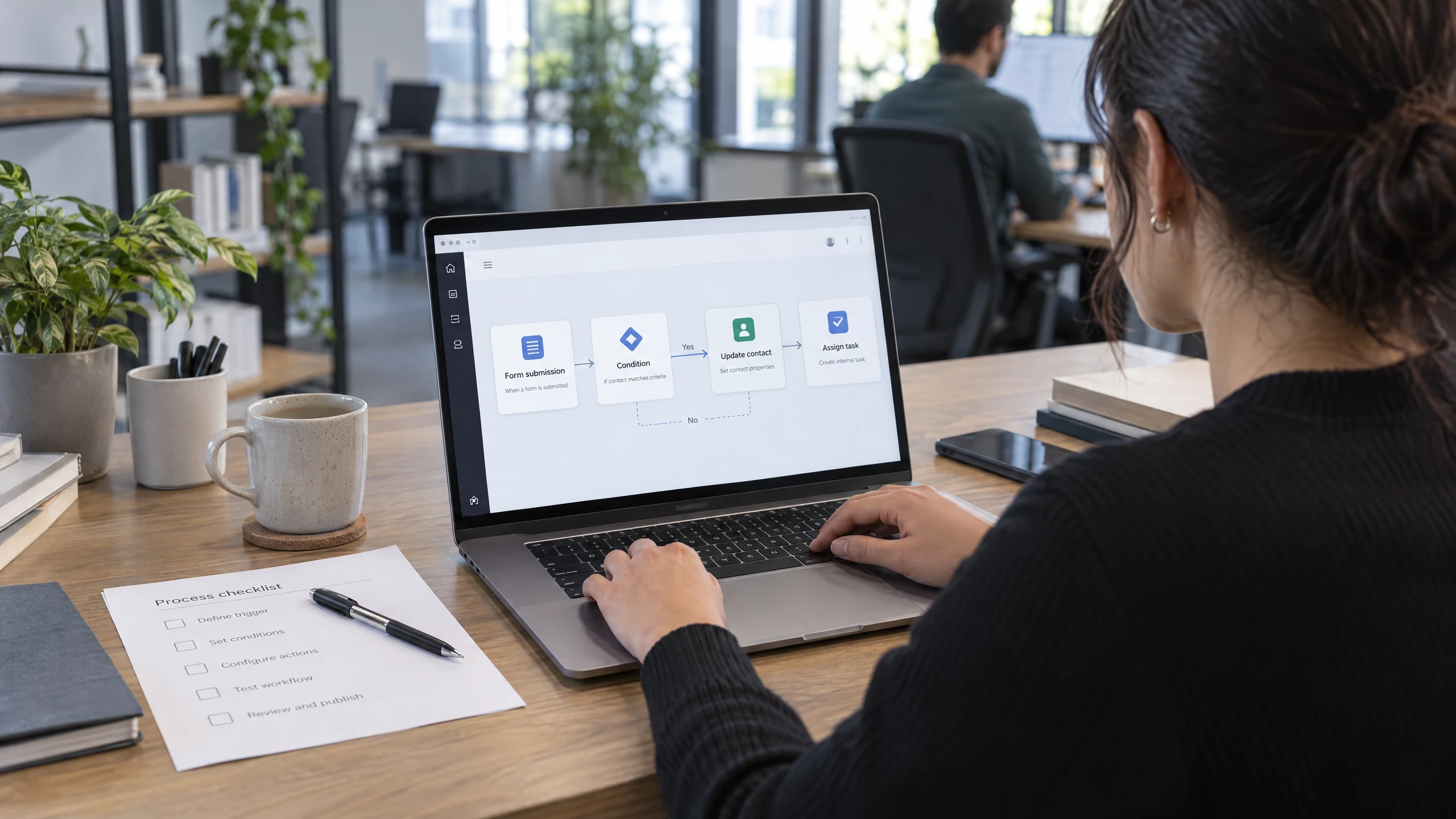 Operations designer configuring a form trigger, condition, contact update, and task assignment sequence on a laptop (illustrative)