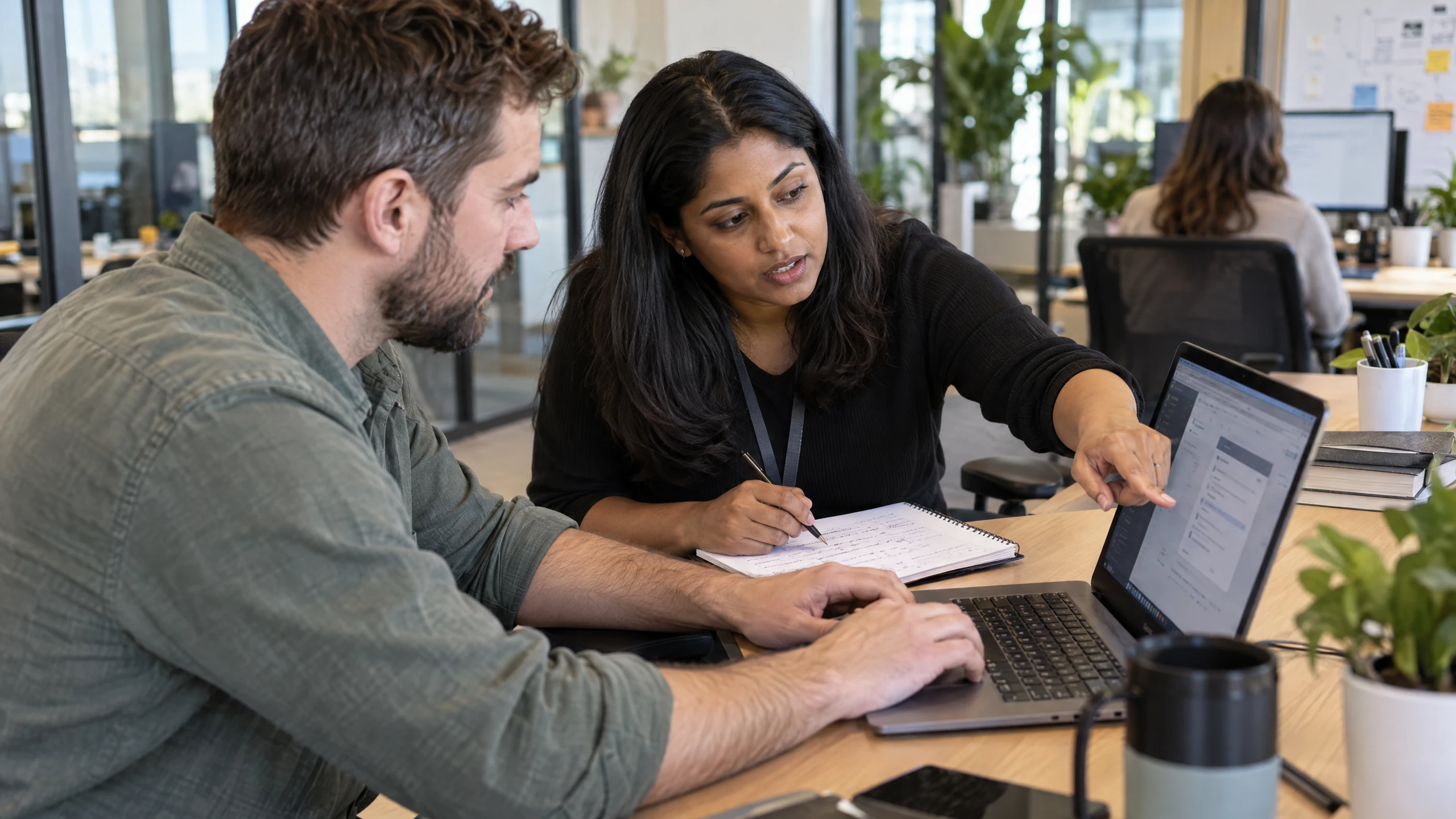 Support specialist clarifying an employee's reported workflow problem beside a laptop and diagnostic notes (illustrative)